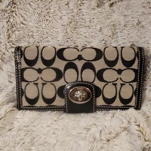 Coach black and white monogrammed wallet with a checkbook cover.